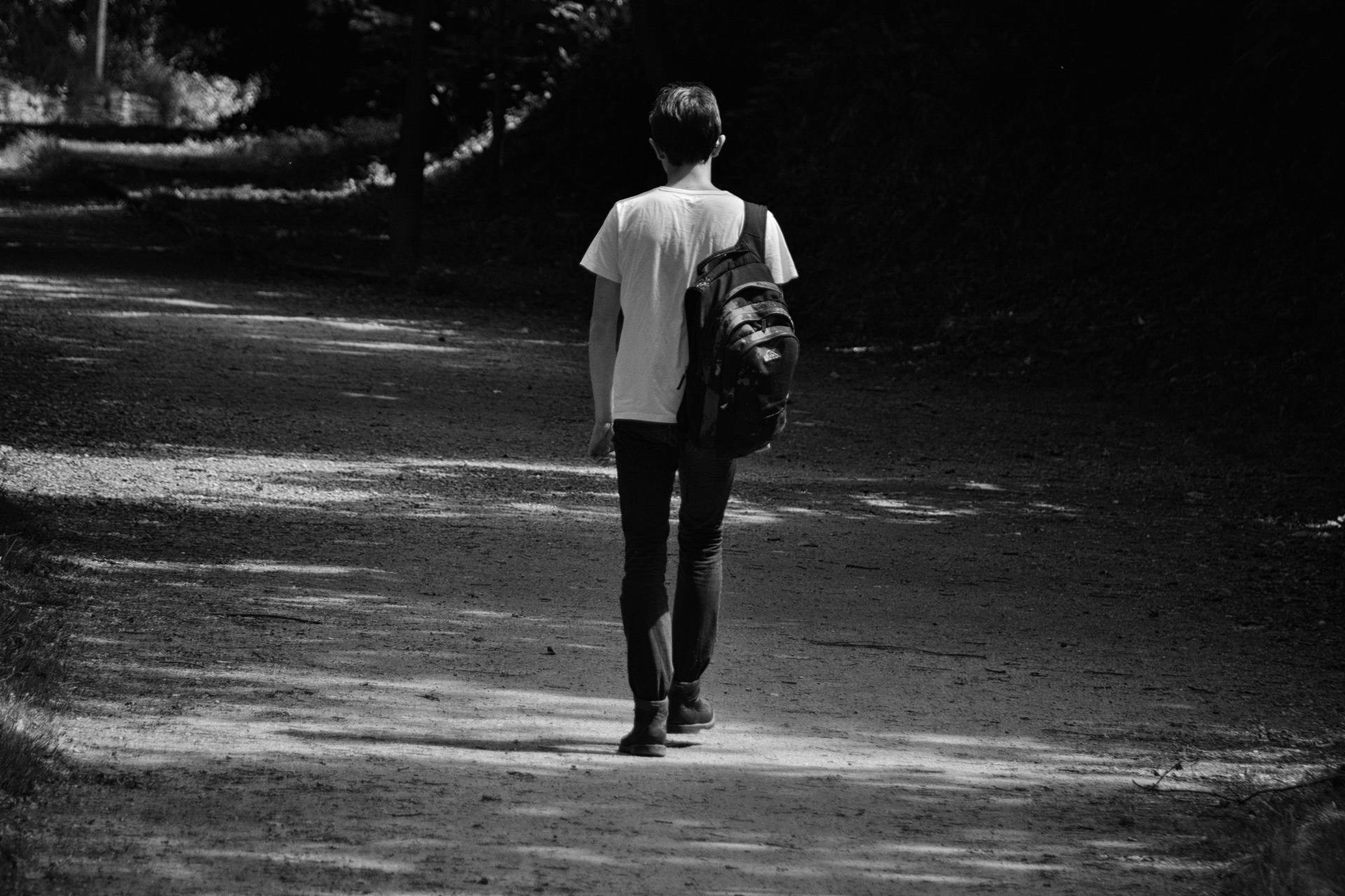 Young man seen from behind walking alone