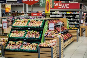 Grocery store displaying a variety of apples, peaches, and nectarines with large “Save” signs