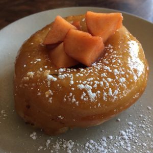 A round donut topped with passion fruit and powdered sugar.