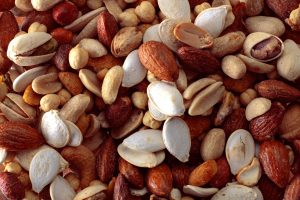 Mixed nuts and seeds, including peanuts, almonds, pistachios, and pumpkin seeds.