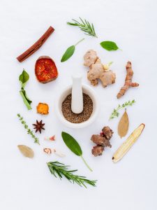 Variety of herbs and spices, including cinnamon stick, turmeric, rosemary, bay leaves, ginger root, and cumin seeds.