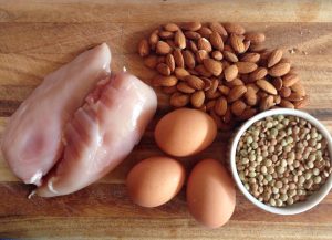 Raw chicken, brown eggs, almonds, and uncooked lentils.