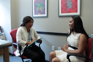 Health-care provider taking notes during a visit with a patient.