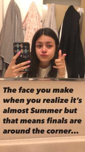 Meme of a young woman taking a selfie in a bathroom mirror with a slight smirk, gesturing with her hand pointing like a finger gun, and the words &quot;The face you make when you realize it&#039;s almost Summer but that means finals are around the corner...&quot;.