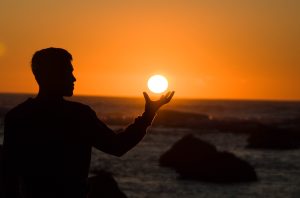 shadow of a man holding the sun