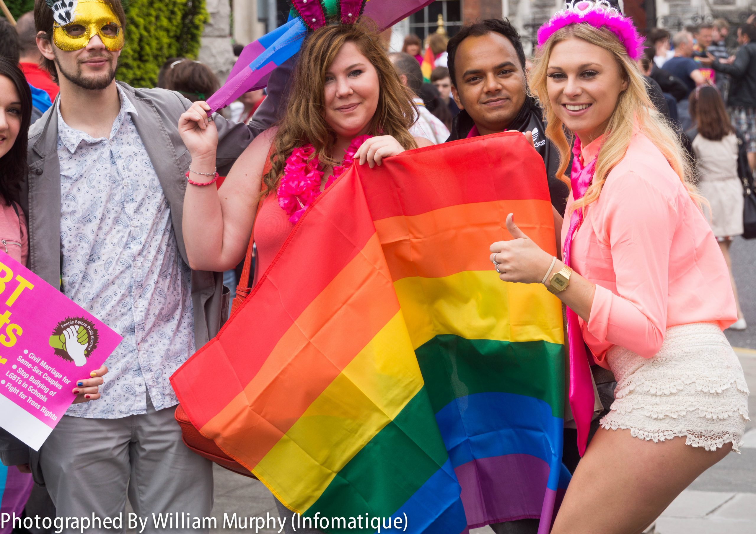 ”Pride_Festival_2013_On_The_Streets_Of_Dublin_(LGBTQ)_(9183775778).jpg” by infomatique is licensed under CC BY-SA 2.0 Photo showing a group of four people celebrating Pride Festival for the LGBTQ Population