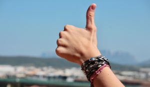Ocean with someone giving a thumbs up in front of the camera
