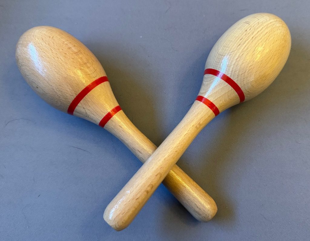Two hand held wooden shakers for making a rattling noise