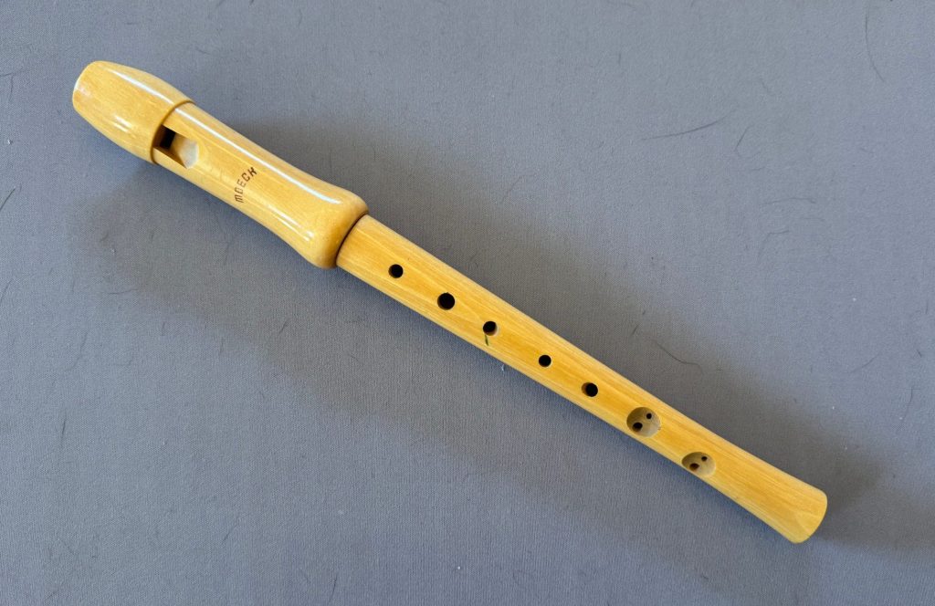 A picture of a recorder type block flute in a blond wood