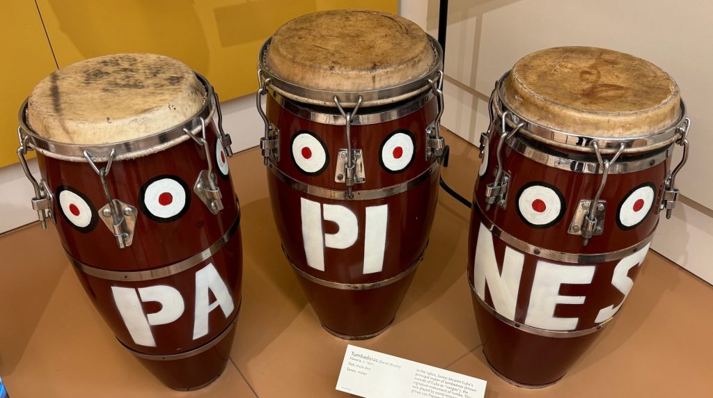 Three tall wooden drums that are hit on the top with the hands.